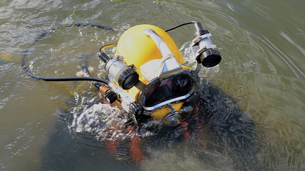 Commercial diver prepares to descend below fishing vessel to perform repairs. Image credit: iStock / Getty Images Plus