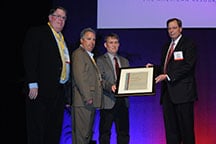 Mark Somers, Warren Gross, and Tom Parks of Lockheed Martin accept the award from Jeff Kohler of OMSHR.