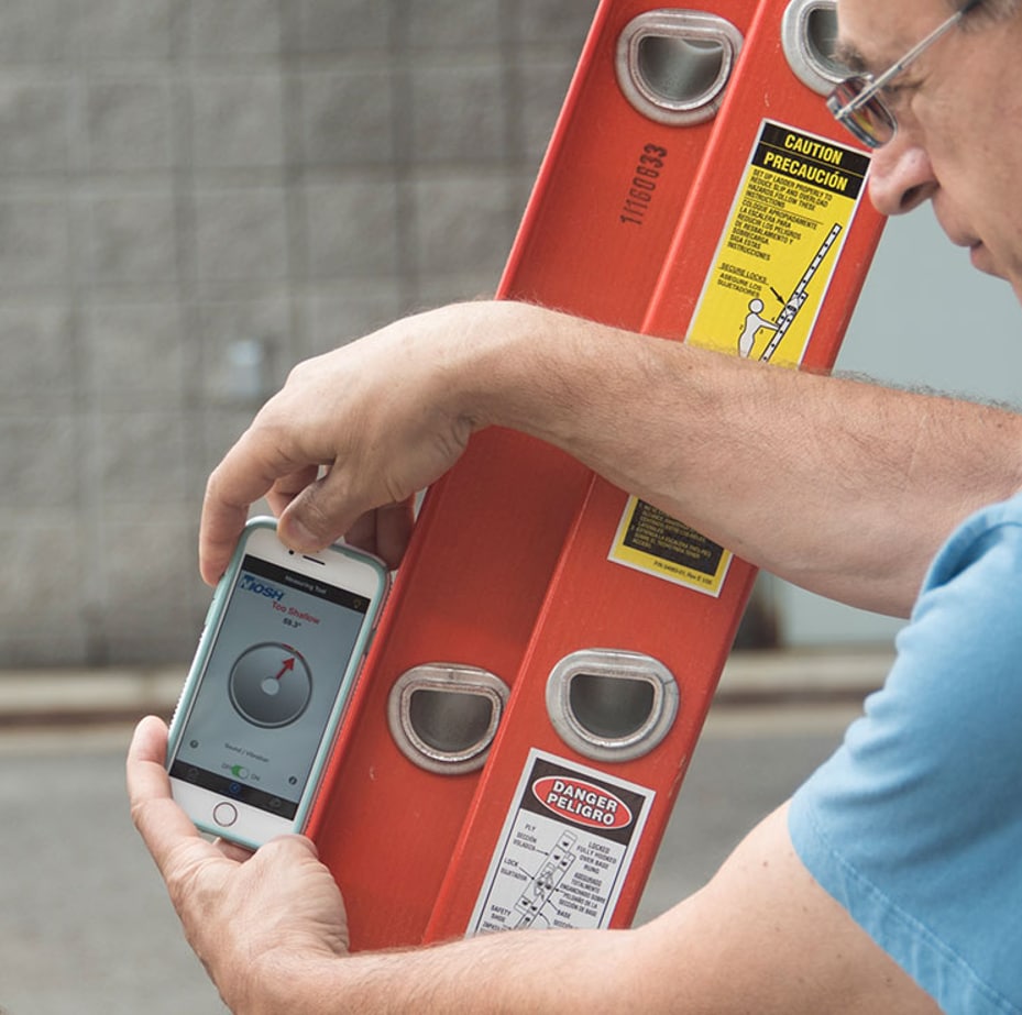 photo of a man using the Ladder Safety App on a mobile phone to position an extension ladder