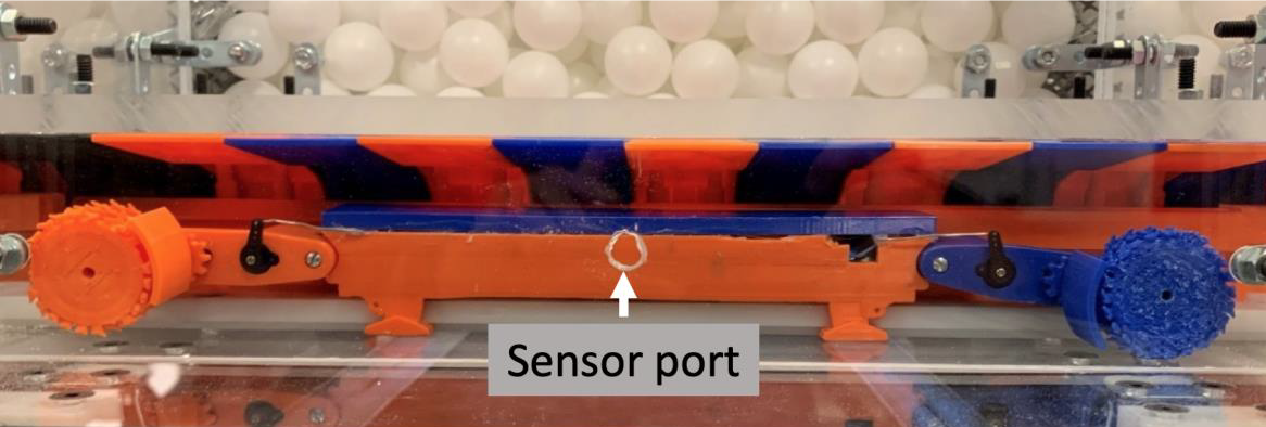 Photograph showing a close-up of a 1/40th scale longwall shearer and central sensor location on model's mine face. Also shown are simulated longwall shields and gob material (spheres) in gob.