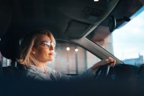 Side view of woman driving car