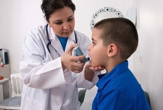 Doctor helping child with inhaler.