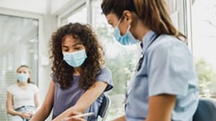 Adolescents wear masks as they wait at a doctor's office