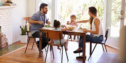 A young couple and their toddler son interacting during a meal.