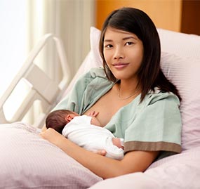 Mom breastfeeding her newborn while still in the hospital after giving birth.