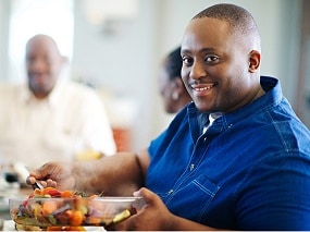 A man dishing out a fruit salad