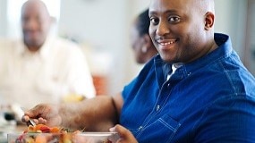 Man getting fresh fruit from a large bowl.