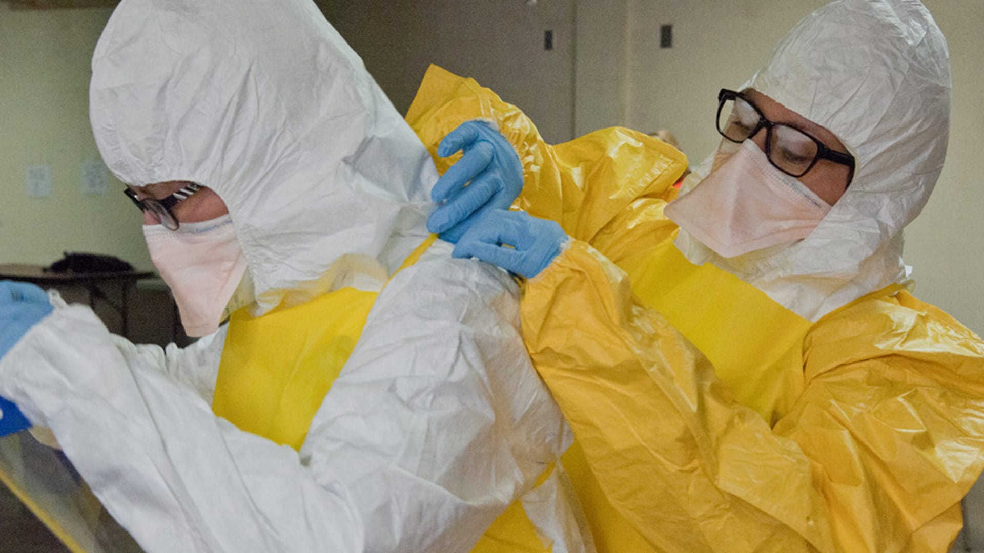 Lab workers securing personal protective equipment