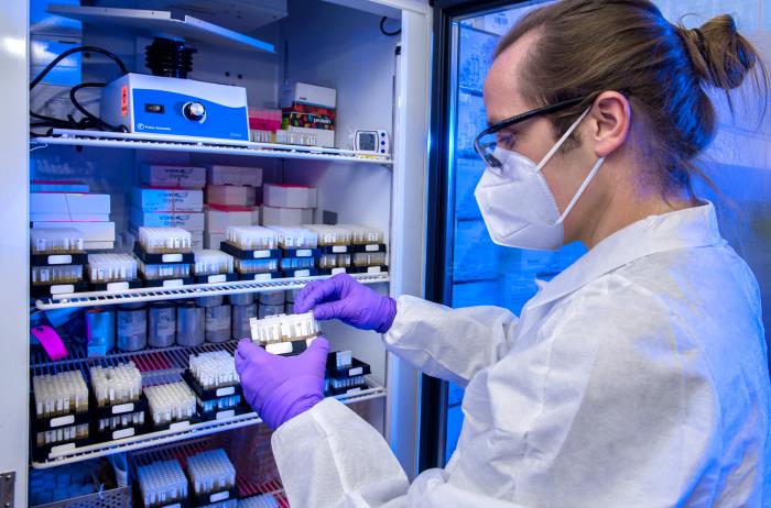 laboratory inventory female lab tech wearing PPE holding sample