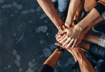 Group of people putting their hands on top of each other