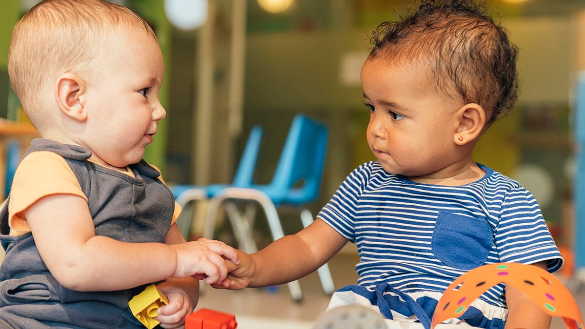 Two toddlers playing together at preschool.