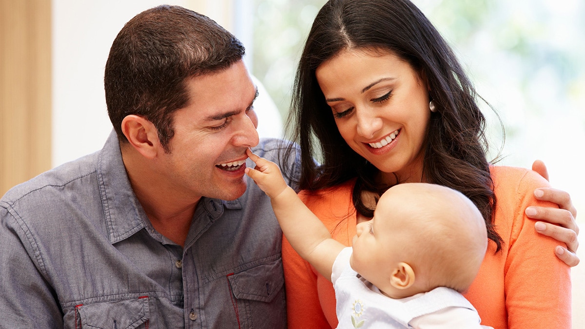 Hispanic couple at home with baby