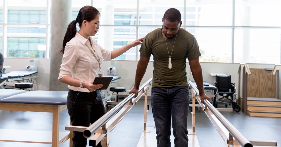 Man with doctor in rehabilitation learning to walk