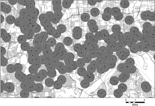 This figure is a map of a portion of the cities of Minneapolis-St. Paul, Minnesota, and shows the locations of approximately 200 schools within the approximately 160-square-mile area illustrated. Around each school location is a circle with a one-half mile radius. Many of the circles have portions that overlap other circles.