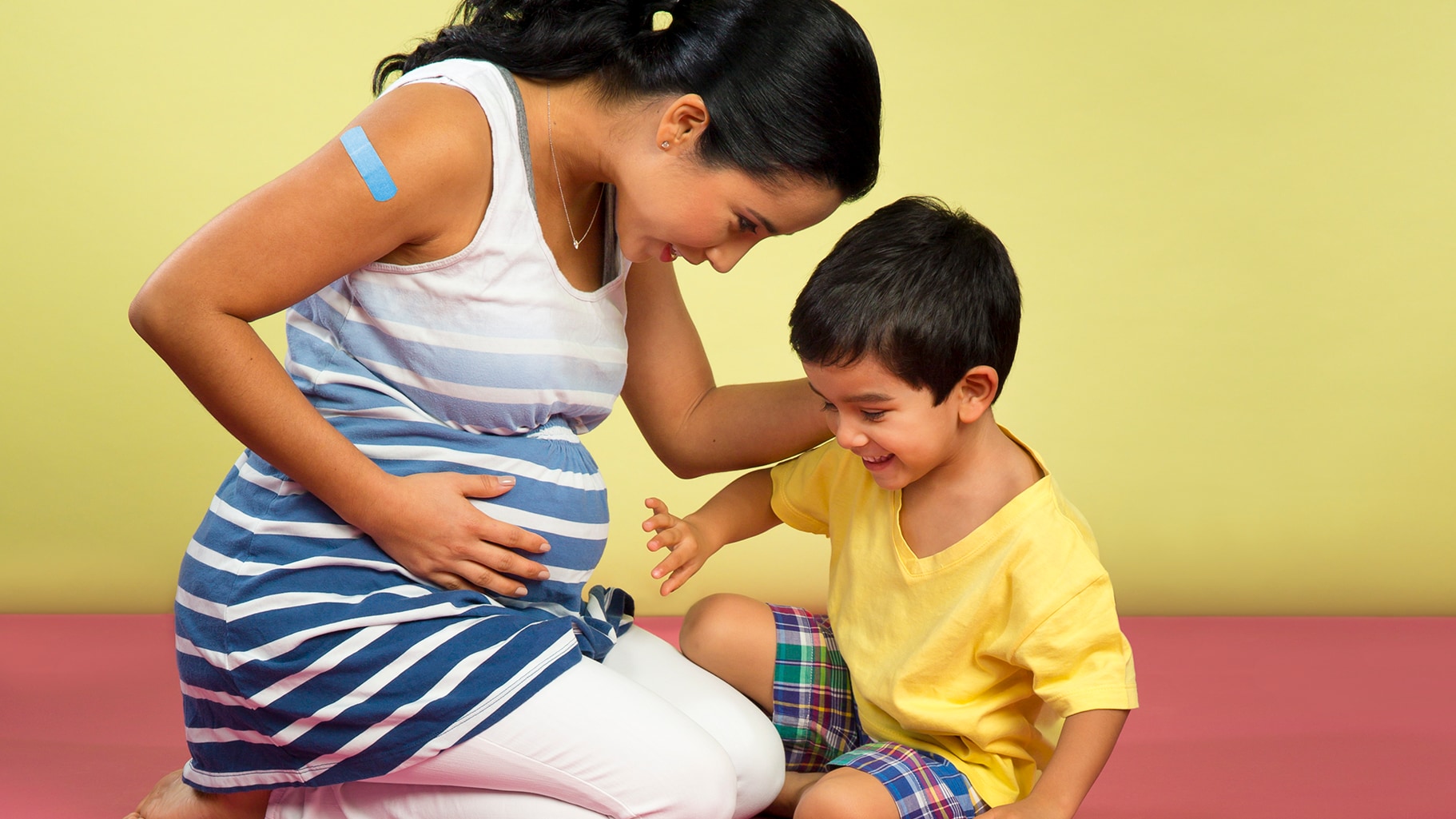 Pregnant mother sitting with her son.