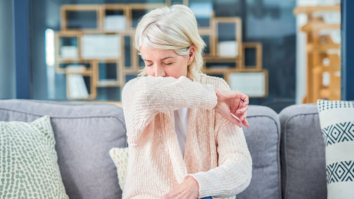 Woman feeling ill on the sofa at home.