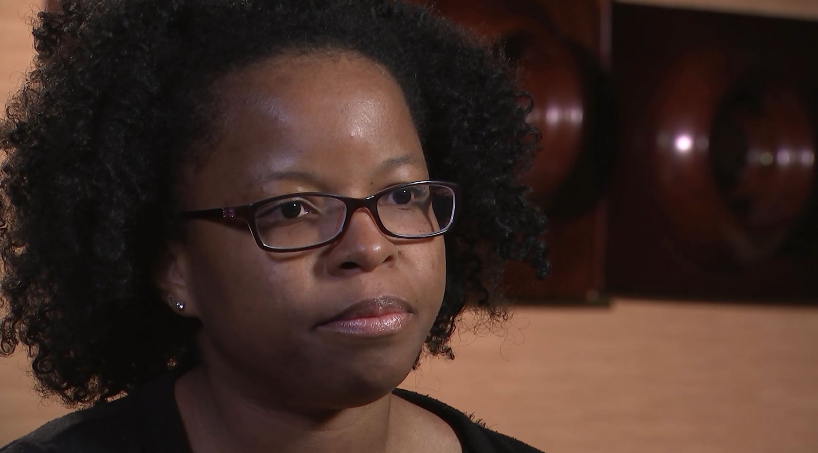 A woman wearing glasses and a black shirt.