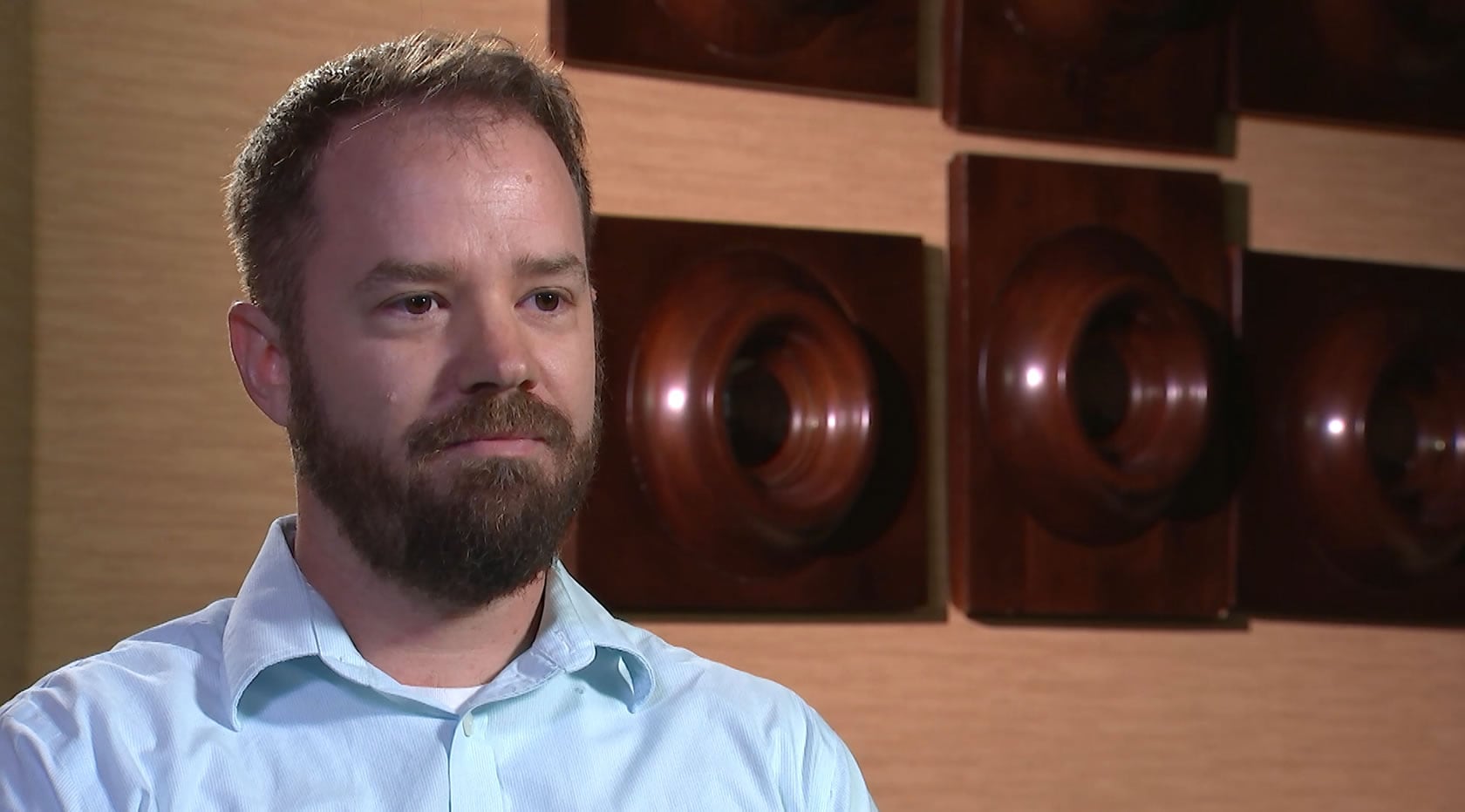 A bearded man wearing a blue shirt.