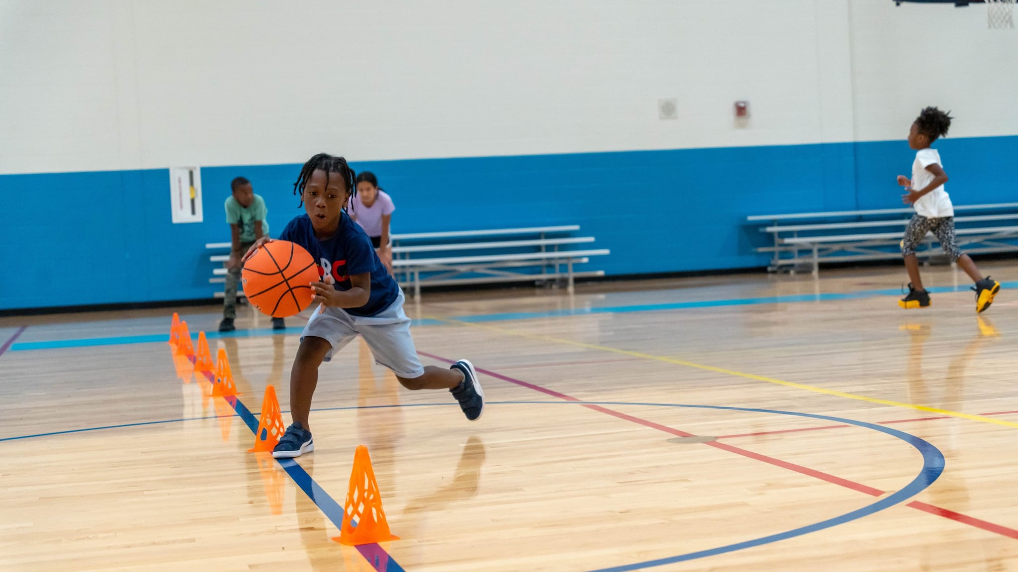 Kids playing basketball in a school gym.