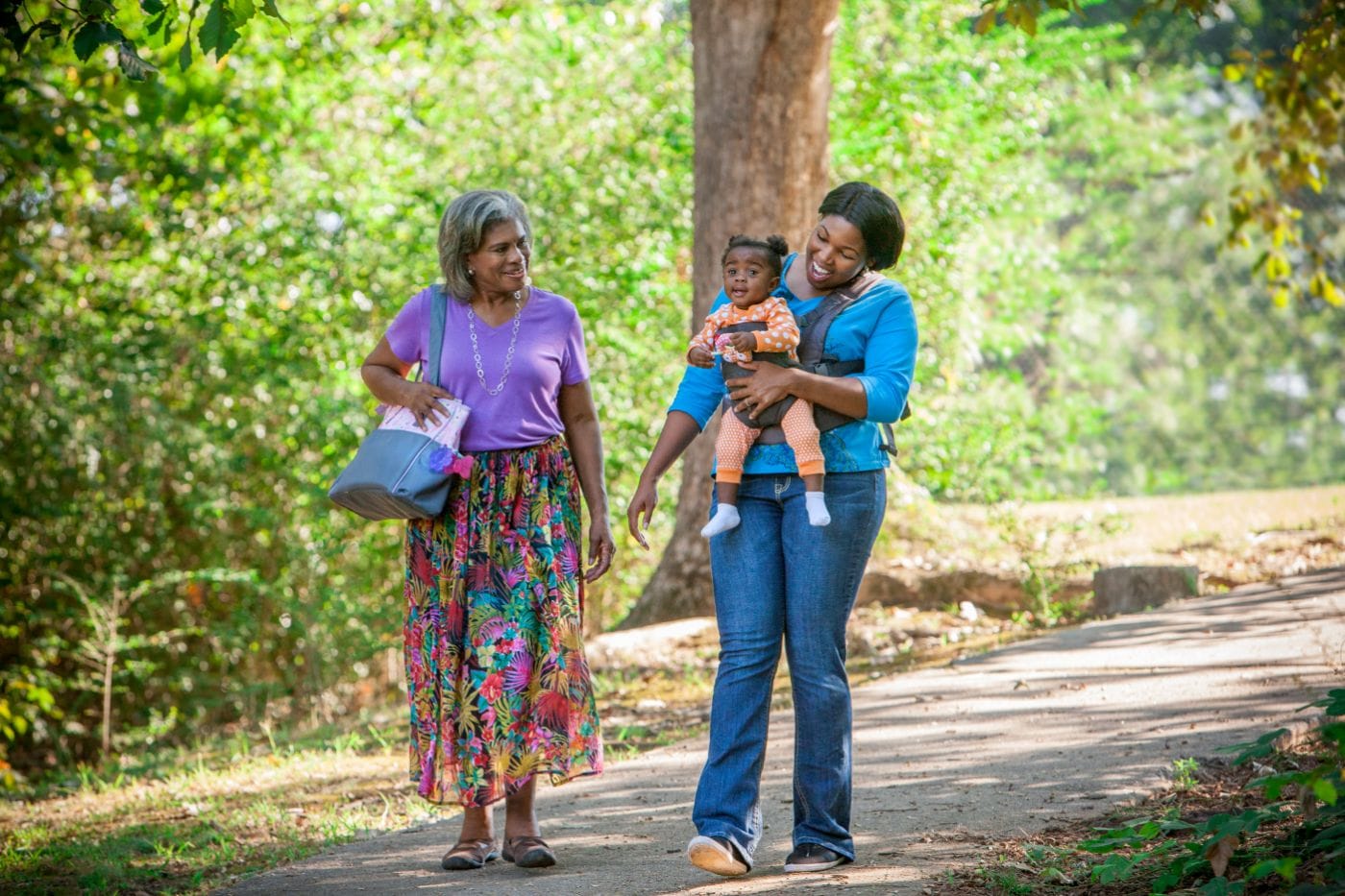 2 women and a child walking in the the park