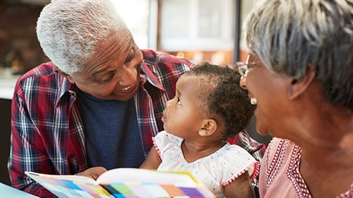 Two older woman laugh with young child