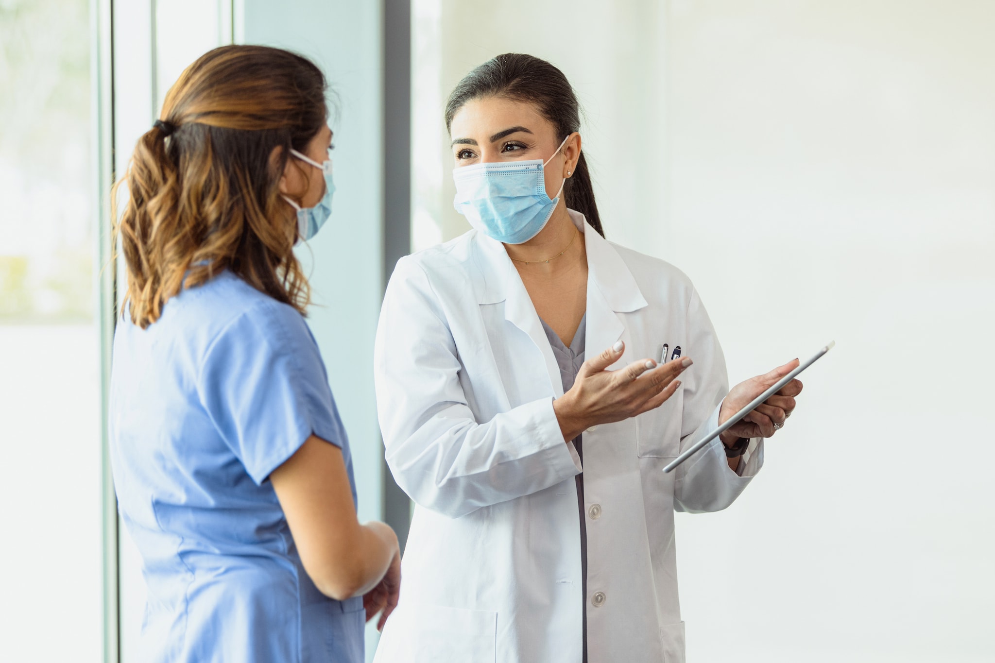 Female healthcare professionals discuss a patient's chart.