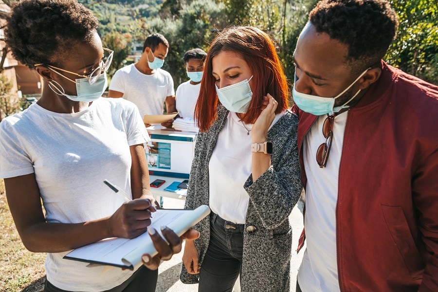 Woman with clipboard talking to a man and woman