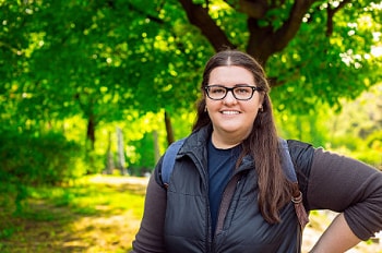 a smiling woman standing outside