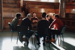 Group of men seated having discussion.