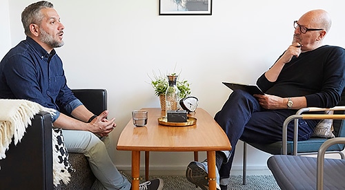 Mature man speaking with older therapist.