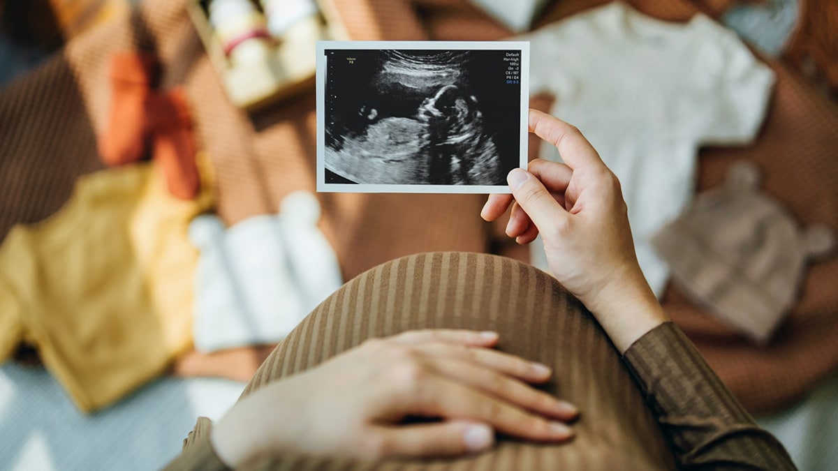 Pregnant person looking at ultrasound image