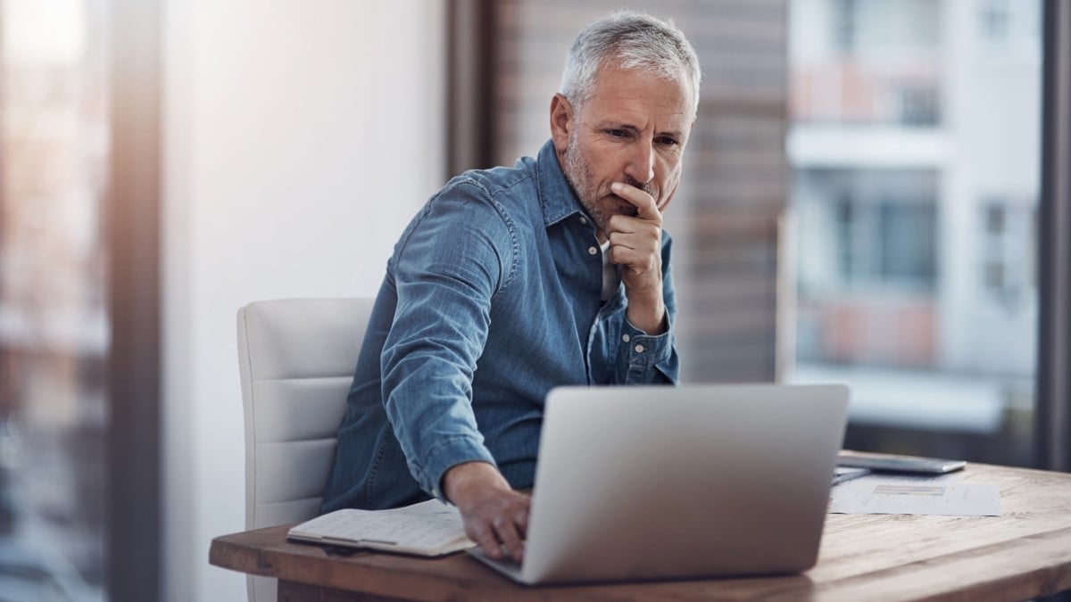 un hombre mirando una computadora portátil