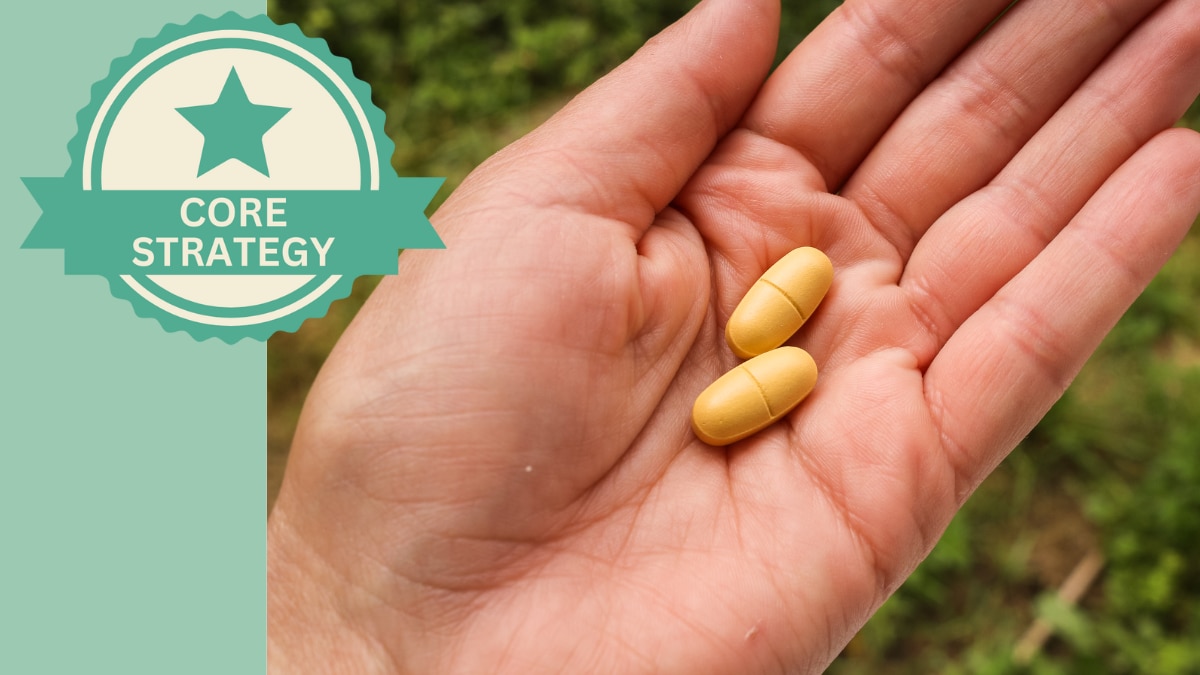 Two pill capsules resting in the palm of an adult hand.