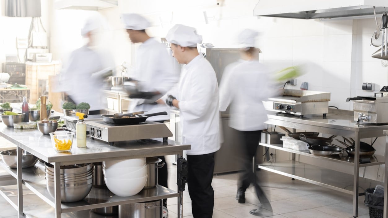 Photograph of food workers in a kitchen.