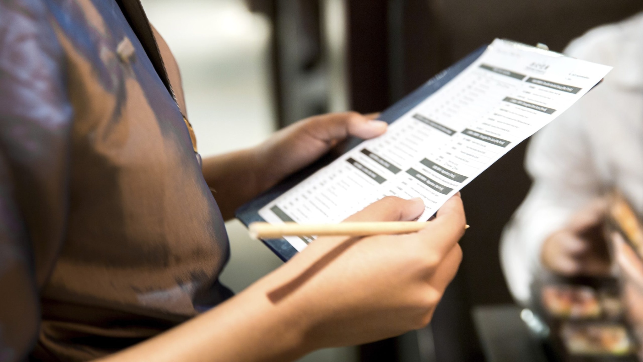 Person holding a paper in a restaurant as part of an outbreak investigation.