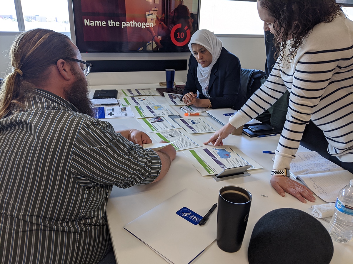 Diverse group of people gathered around a table reviewing documents.