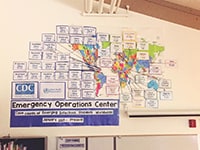 A CDC Emergency Operations Center educational resources hangs on a white board.