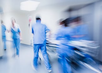 Medical professionals rushing with patient on stretcher in hospital