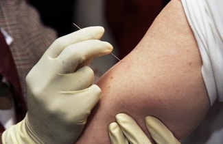 Clinician demonstrates the proper way to administer the smallpox vaccine using a bifurcated needle. Source: CDC's James Gathany.