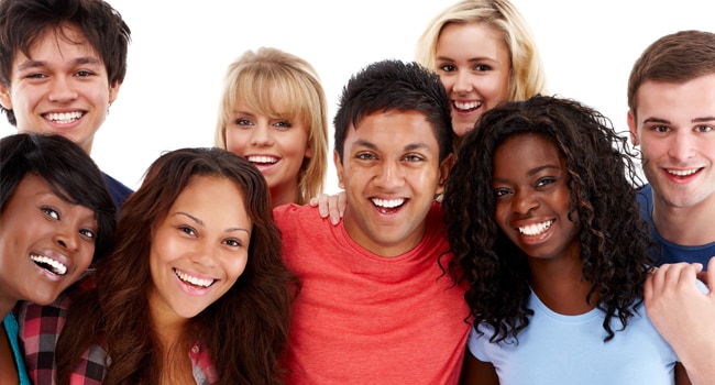 Grupo de jóvenes abrazados sonriendo.