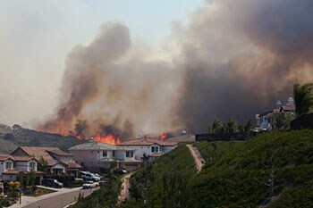 Un incendio forestal cercano a unas casas