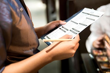 Una mujer está revisando un documento con un compañero de trabajo.