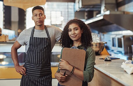 Trabajadora de restaurante e inspectora de seguridad alimentaria en una cocina.