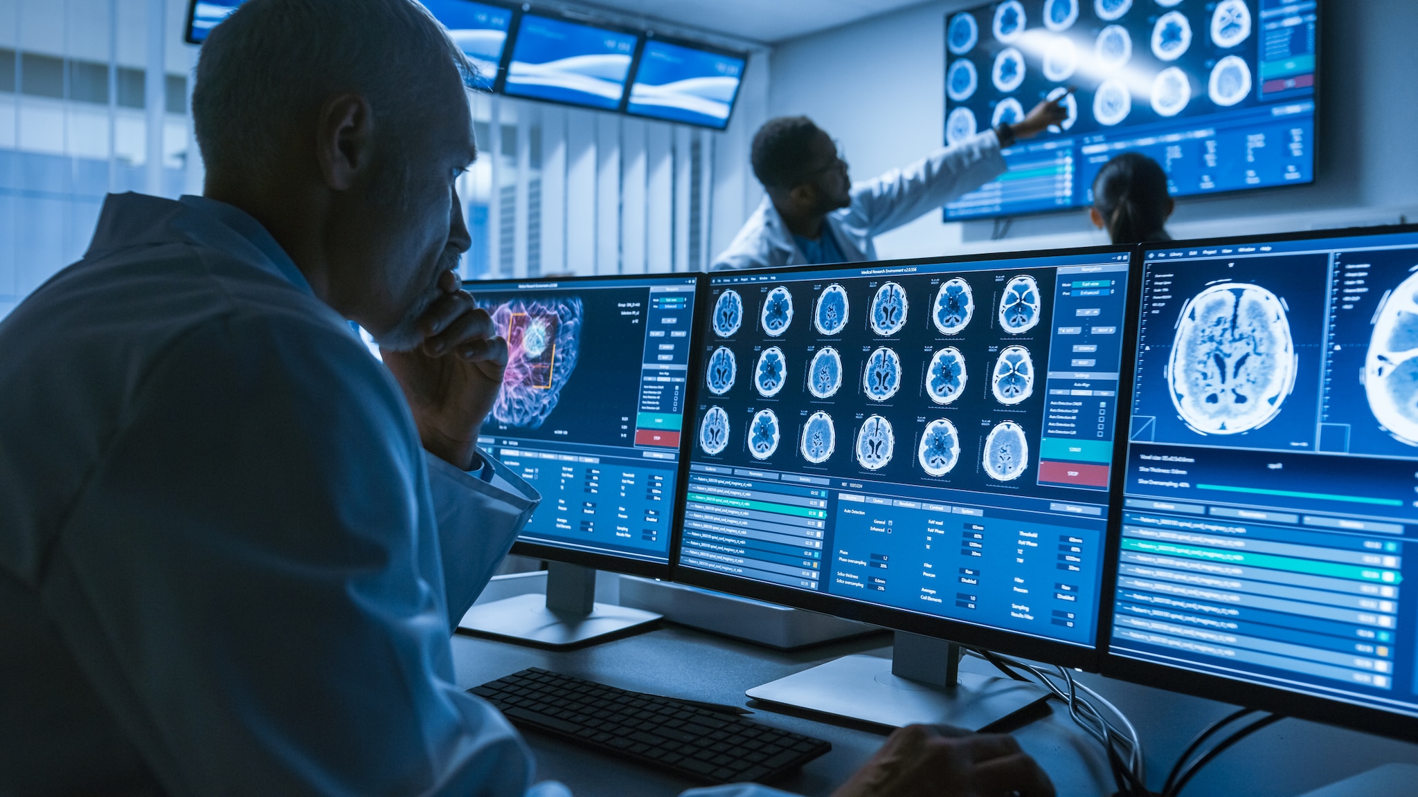 Over the Shoulder Shot of Senior Medical Scientist looking at brain scans.