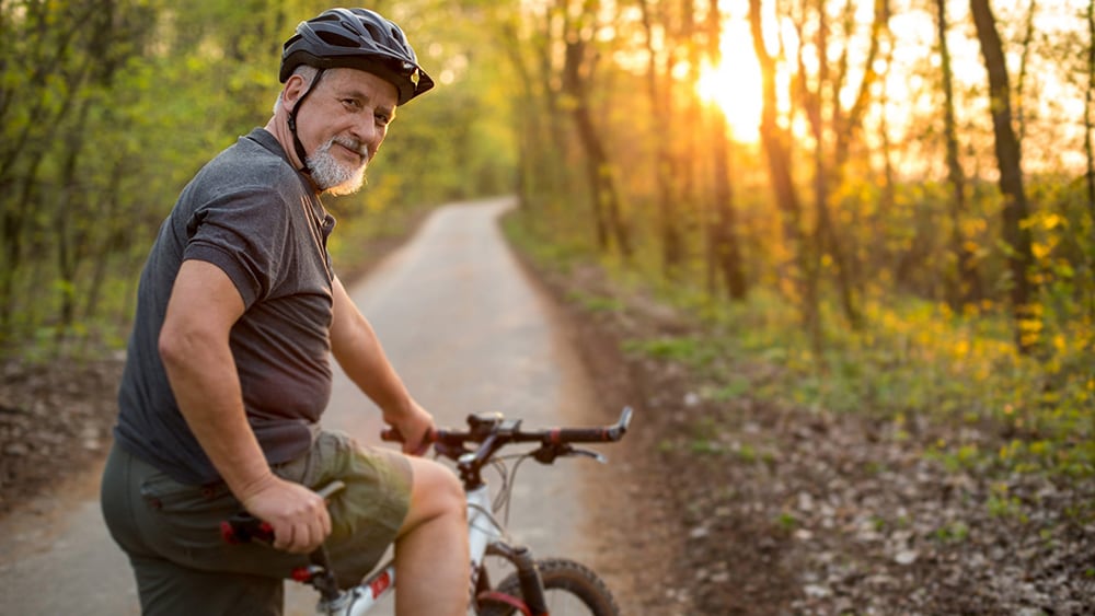 Older man about to get on a bicycle