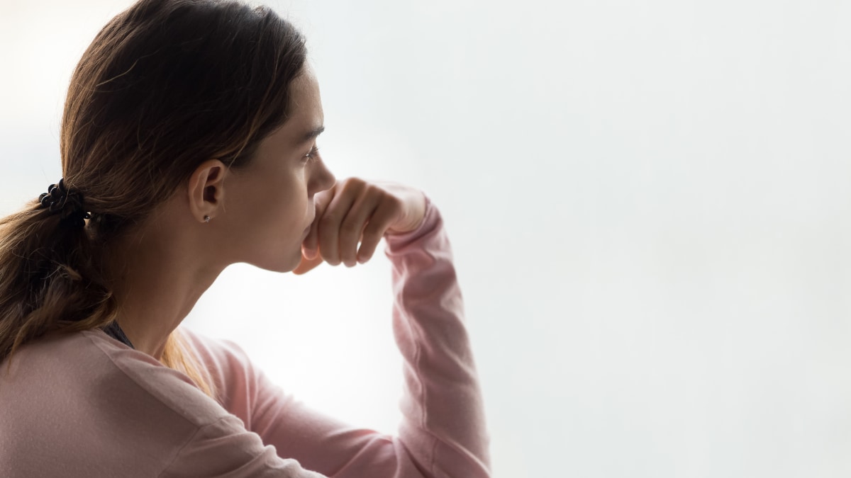 Young woman looking sad stares off into the distance