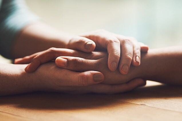 clasped hands on table