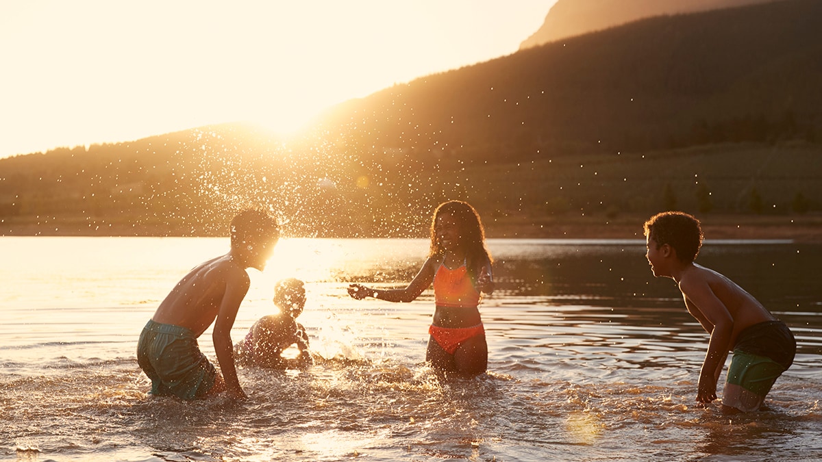 Kids swimming and playing in lake.