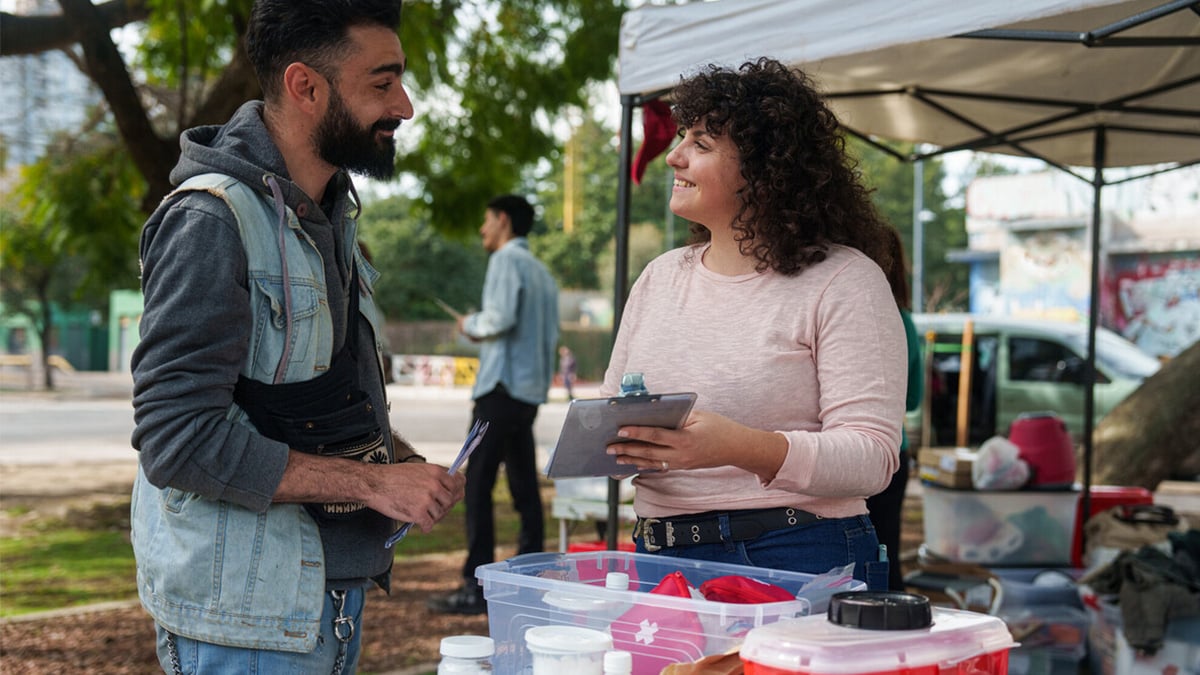 A woman interacts with a man at a syringe services program.