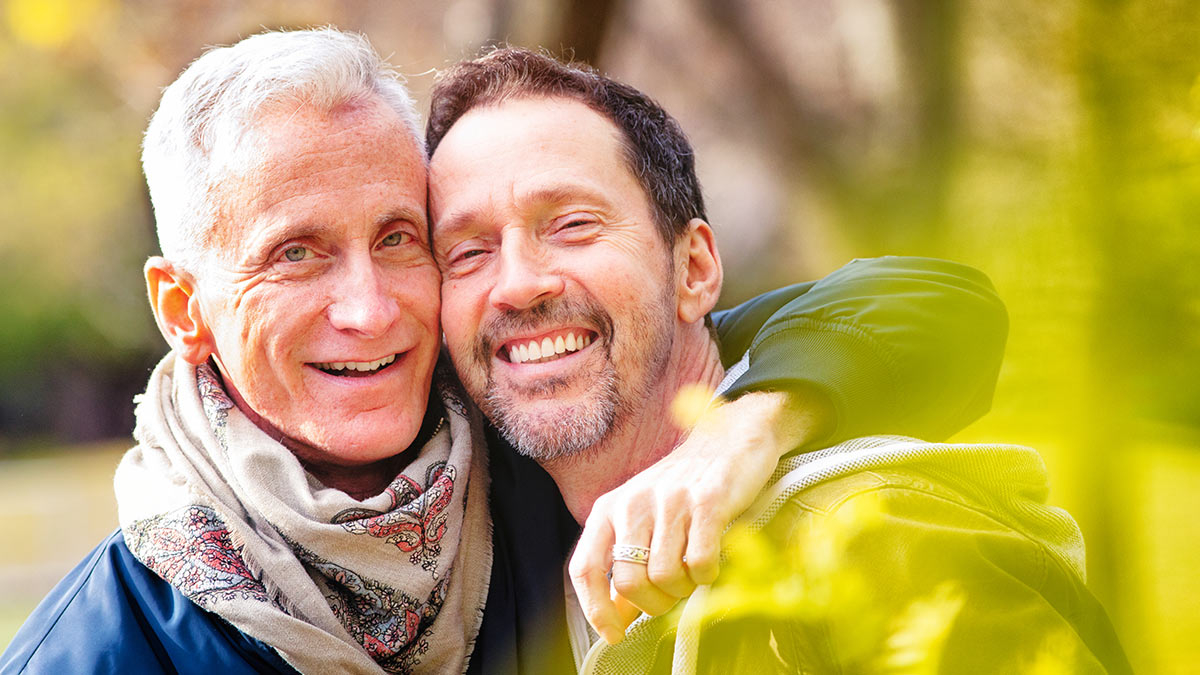 A gay couple smiling at the camera